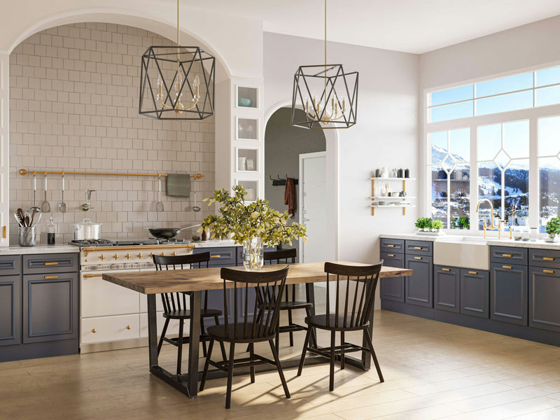 A bright, modern kitchen is adorned with a large Trapezoid Dining Table in Harvest Wheat by James+James, paired with black chairs. The kitchen highlights blue lower cabinets, white upper cabinets, a tiled backsplash, and two geometric pendant lights. Expansive windows flood the space with natural light and offer a snowy mountain view outside.