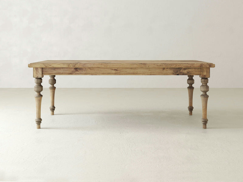 The Allyson Dining Table - Harvest Wheat from James+James is a rectangular wooden dining table with a light natural finish and four turned legs, standing against a light-colored, plain background. It boasts a rustic and minimalist design with smooth edges.