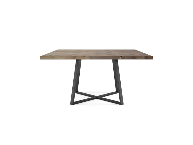 The Watson Square Dining Table - Barn Wood by James+James features a thick, light brown tabletop with a square design. Its minimalist, industrial style is accentuated by a metal base with two legs forming a geometric, crisscross design in black.