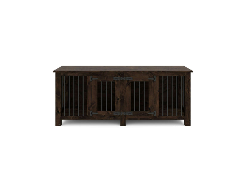 The James+James Double Dog Kennel - Tobacco is a rustic, farmhouse-style dark brown wooden dog crate featuring metal bars on three sides and double doors with black hinges and latch in the front. It also has a flat top surface that can be used as a tabletop.