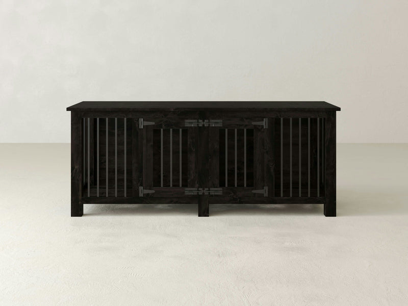 The James+James Double Dog Kennel - Charred Ember showcases a minimalist aesthetic with its three compartments, each enclosed by vertical slats. The center compartment features a door that swings open and is secured with two metal hinges. The kennel stands on four sturdy legs and is set against a plain white background.