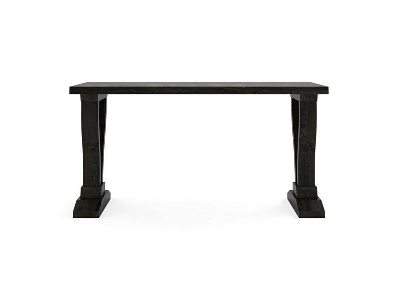 The Vera Sofa Table - Charred Ember by James+James features a black wooden rectangular top supported by two sturdy, carved legs on each side, showcasing a simple yet classic design. The table is set against a plain white background.