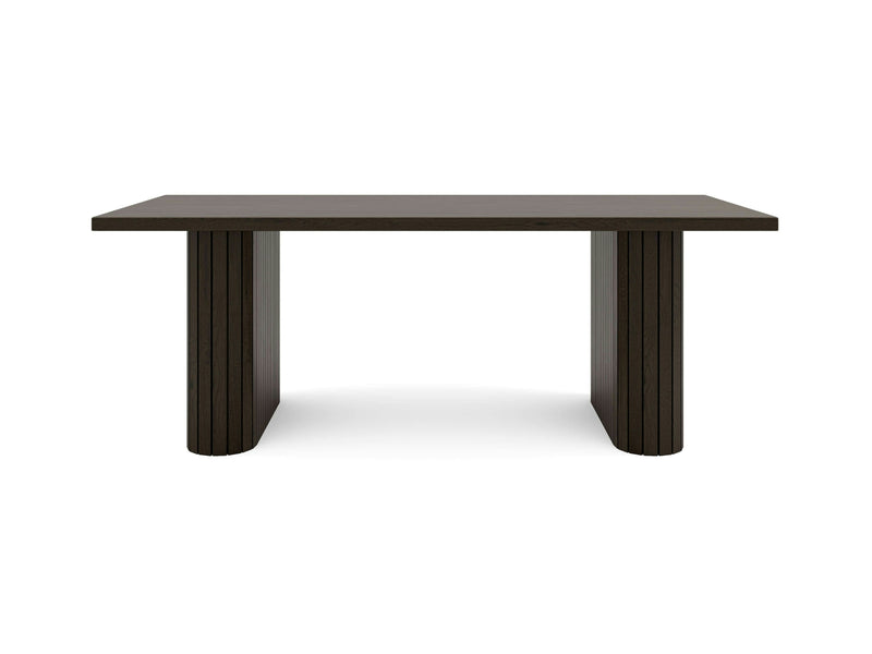 The Fern Dining Table - Charred Ember by James+James features a dark brown wooden rectangular top with a smooth finish, supported by two thick, solid, rectangular legs on each side. Its design embraces simplicity and modernity with clean lines and a minimalist aesthetic.