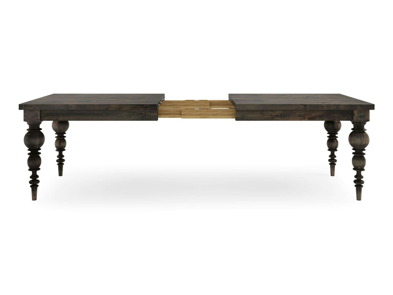 The Bailey Expandable Dining Table in Deep Grey by James+James showcases a dark wooden design with an extendable section at the center, revealing a sophisticated construction extension mechanism. It features intricately carved, turned legs and a rustic finish, presented against a white background.