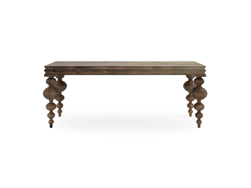 The Olivia Sofa Table by James+James features a rectangular top with intricately carved, bulbous legs. Crafted from barn wood, it boasts a natural, slightly weathered finish for a rustic appearance. The table is photographed against a plain white background.