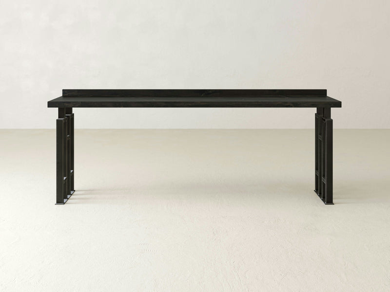 Introducing the Clark Sofa Table - Charred Ember by James+James: This modern black console table features a sleek rectangular top and minimalist metal legs with open rectangular cutouts, creating an eye-catching geometric design. Its contemporary and elegant aesthetic makes it perfect for a stylish home or office setting.