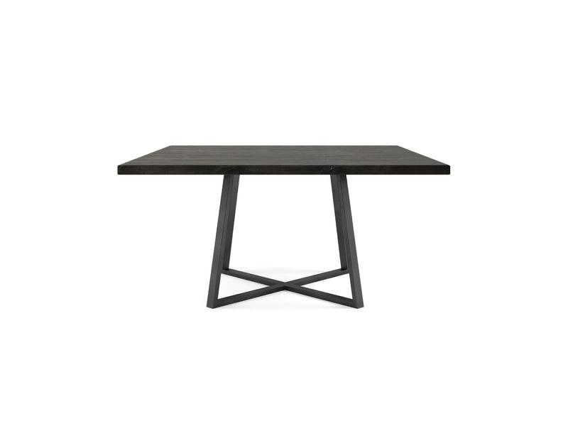 A modern dining table, the Watson Square Dining Table - Charred Ember by James+James, features a wooden tabletop with a dark finish. It is supported by a sleek black metal base with an X-shaped design for added stability and contemporary aesthetic. The table is empty and positioned against a white background.