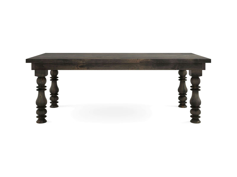 The Annli Dining Table by James+James features a robust, deep grey wooden rectangular top and four intricately turned legs. Its rustic design is highlighted by the natural wood grain finish, creating a striking contrast against the plain white background.