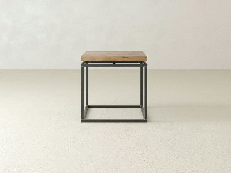 The Floating Top End Table by James+James is a minimalist side table showcasing a hardwood top and a sleek black metal square frame base. Ideal for modern decor, this end table is set against a plain, light-colored background.