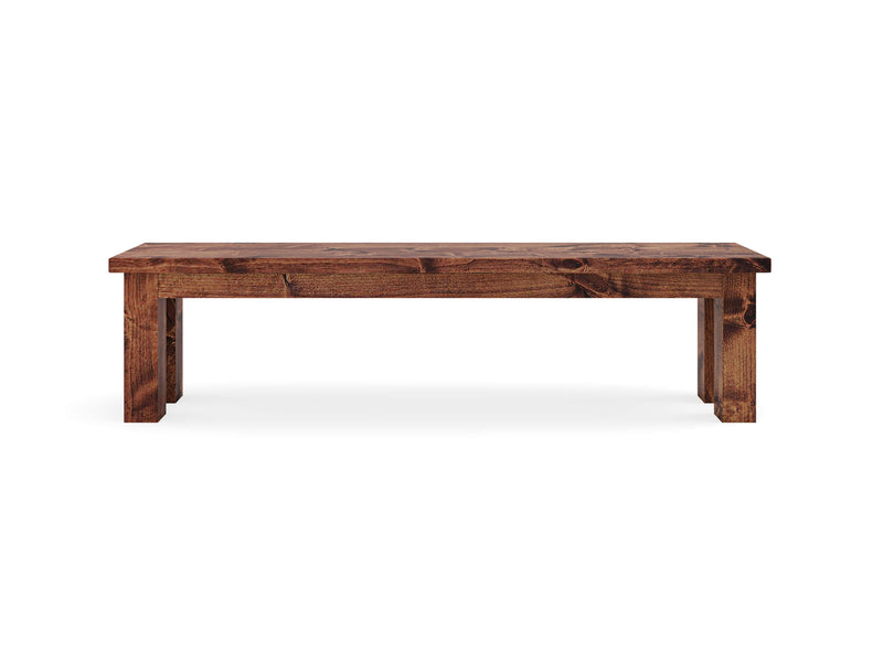 The James+James Farmhouse Bench - Tuscany features a simple, rustic design with a rectangular seat and four sturdy legs, all crafted from dark-stained wood. This classic, minimalist piece is suitable for both indoor and outdoor settings. The bench is showcased against a plain white background.