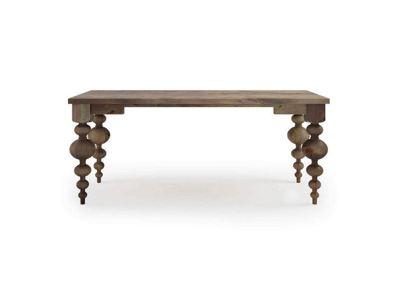 The Olivia Desk - Barn Wood by James+James features a rectangular wooden top and intricately turned legs. It boasts a rustic finish, with four sturdy legs adorned with decorative, spherical carvings. The desk is showcased against a plain white background.