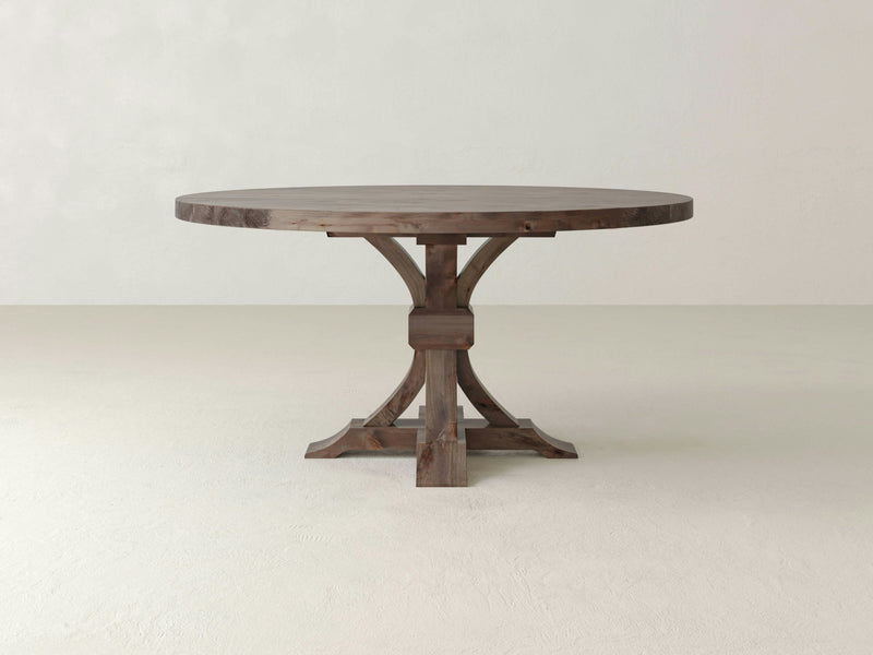 Close-up of the Violet Round Dining Table - Barn Wood by James+James shows a distinctive knot in the grain. The knot is dark and irregularly shaped, surrounded by lighter shades of brown wood, highlighting its unique texture and pattern. The surface appears smooth with a natural, earthy appearance.