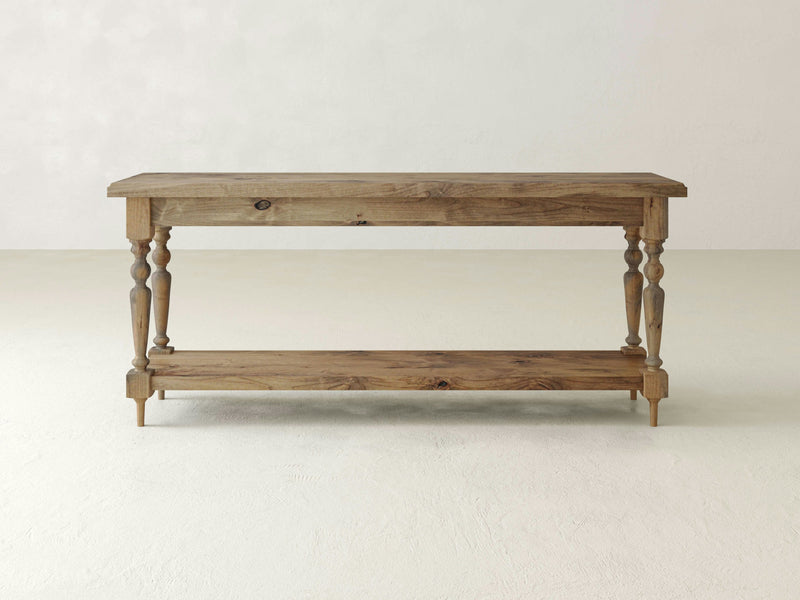 The Ella Sofa Table - Harvest Wheat by James+James is a rustic wooden console table featuring a rectangular top and bottom shelf. With its turned legs and natural wood finish, it exudes a charming vintage and farmhouse appearance.