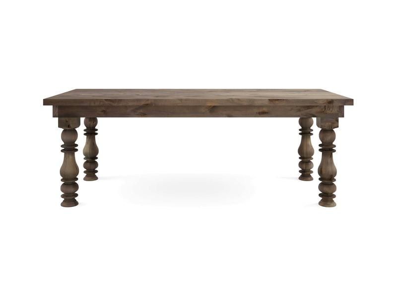 The Annli Dining Table by James+James features a rectangular wooden design with a smooth top and intricately carved turned legs. Made from barn wood, it showcases a rustic, slightly distressed finish that lends it a vintage appearance. This table exudes a classic yet sturdy design, perfect for various décor styles.