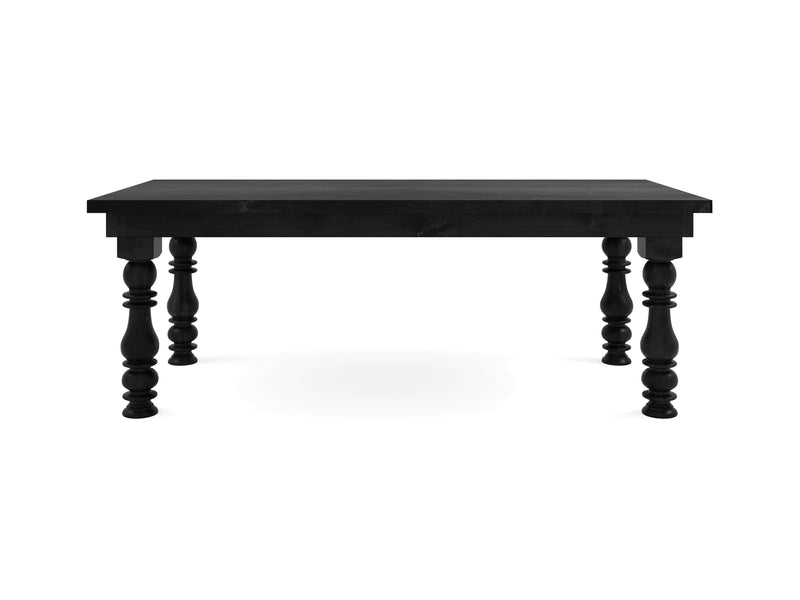 The Annli Dining Table - Charred Ember by James+James is a rectangular black wooden table featuring four intricately carved legs. It boasts a classic, sturdy design and is isolated against a white background.