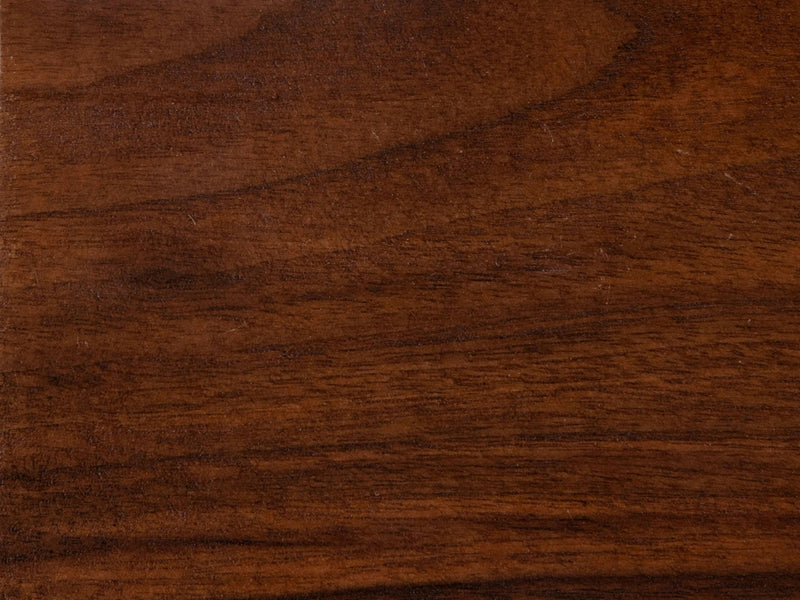 A close-up view of the Tuscany on Black Walnut Sample by James+James features a rich brown color with natural grain patterns that vary in shade. The texture is smooth, showcasing the distinctive lines and subtle variations typical of wood.