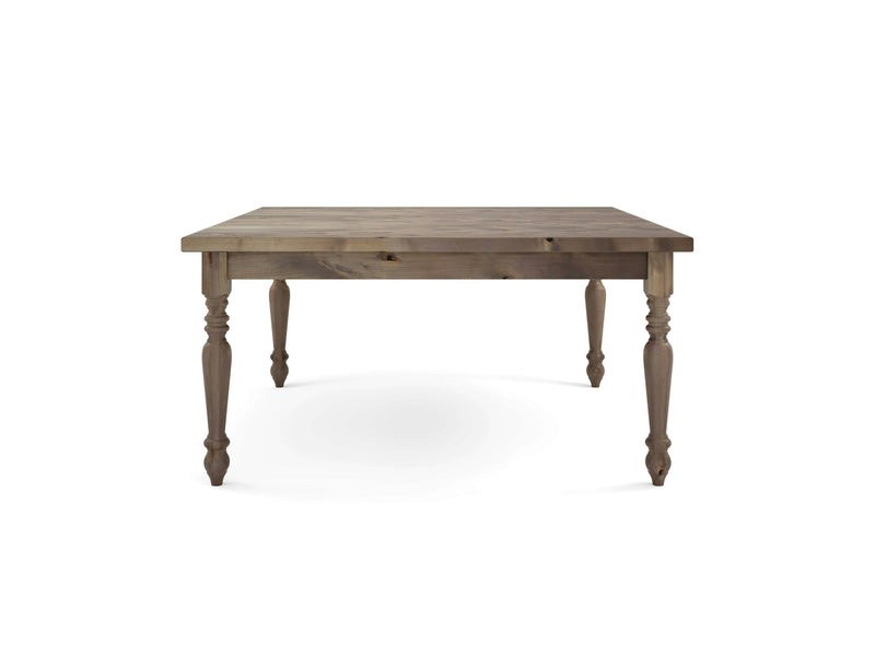 A French Country Square Dining Table - Barn Wood by James+James, showcased on a white background, features intricate carvings on its four legs, a natural wood grain finish, and a classic rustic design.