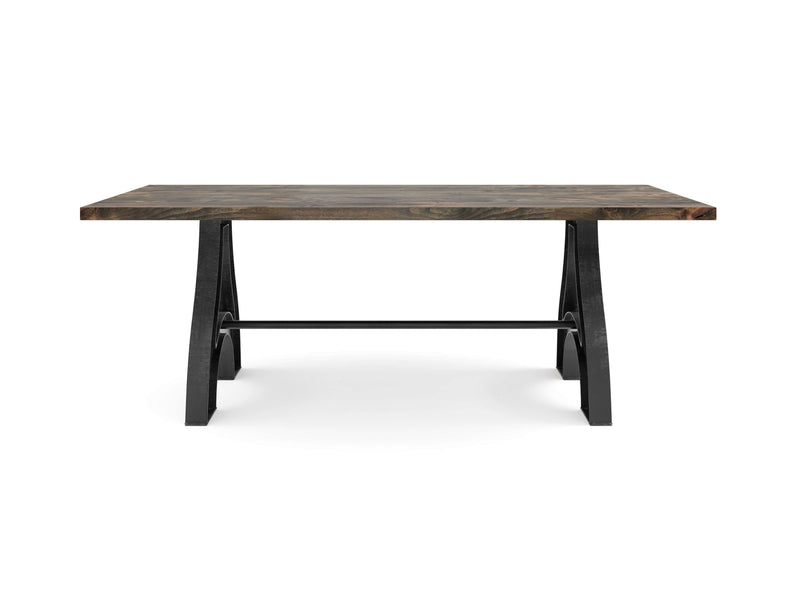 The Wishbone Dining Table - Deep Grey from James+James features a dark wood rectangular dining surface with a thick, flat top and black, angled metal legs connected by a horizontal crossbar, showcasing a modern, rustic design.