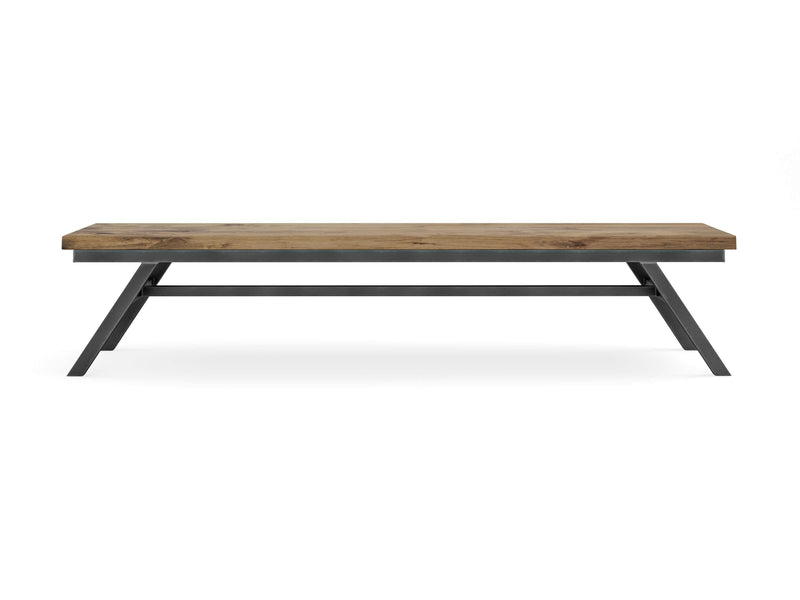 The Fulton Bench - Harvest Wheat by James+James features a rectangular wooden top with a rustic finish and black metal legs. This minimalist piece includes a flat top and angled legs connected by a horizontal support bar. The visible wood grain adds a natural touch to the design.