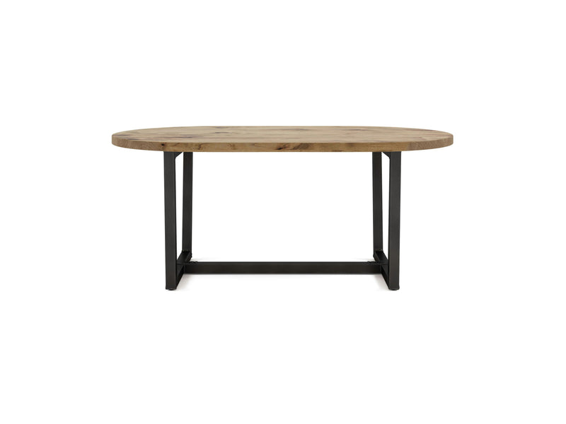 The Trapezoid Oval Dining Table - Harvest Wheat from James+James is a round wooden table with a smooth light brown surface. It is supported by a black metal base featuring two parallel legs and a central bar at the bottom connecting the legs for stability. The design is minimalist and industrial.