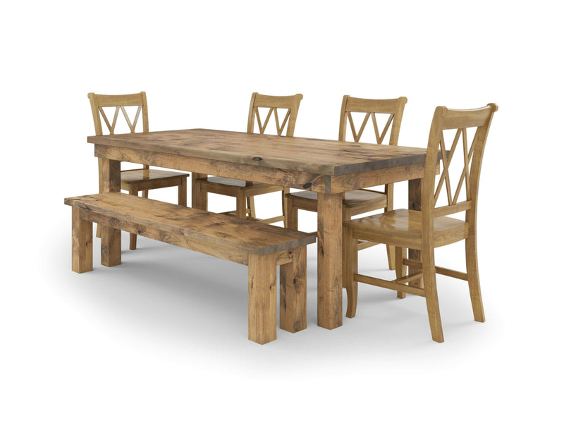 The James & James Farmhouse, Double X-Back & Bench Dining Set includes a rustic farmhouse dining table designed to seat six. This wooden set features four Double X-Back chairs and a long bench on one side. Its solid construction evokes the charm of harvest wheat fields, making it perfect for cozy family gatherings against a plain white background.