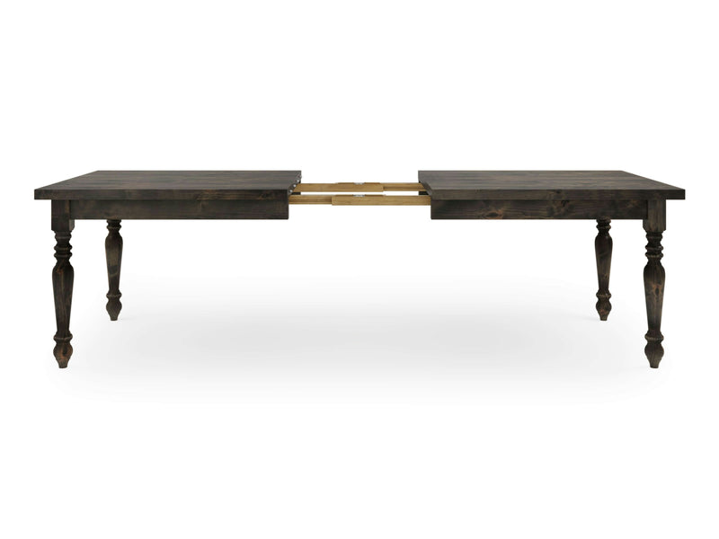 Introducing the James+James French Country Expandable Dining Table in Deep Grey. This elegant piece features intricately carved legs and showcases brass hardware in its extended state. The table boasts a rich, deep grey finish, encapsulating a traditional and sophisticated design.