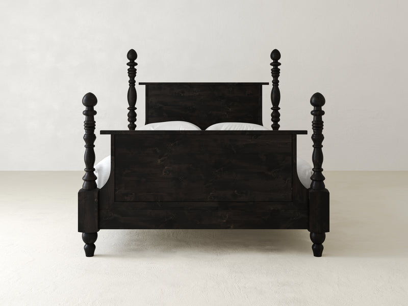 The Catherine Bed - Charred Ember by James+James features dark wood with ornate, turned posts and a matching headboard and footboard, all set against a minimalist white background.