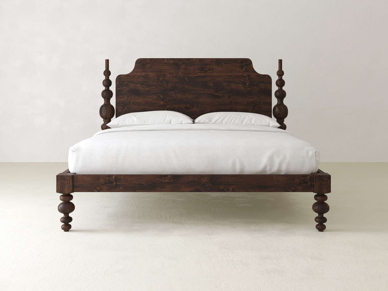 An Opal Bed in Tobacco by James+James showcases a rustic, dark wooden frame with detailed posts and comes with a coordinating headboard. The bed is elegantly made up with white linens and two pillows, set against a simple, light-colored background.