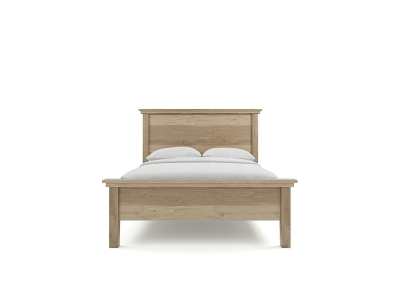 The Ivy Bed - Barn Wood by James+James is showcased with its light wood finish. It features a minimalist headboard and footboard with clean lines. The bed is neatly made with a white duvet and two white pillows, set against a plain white background.