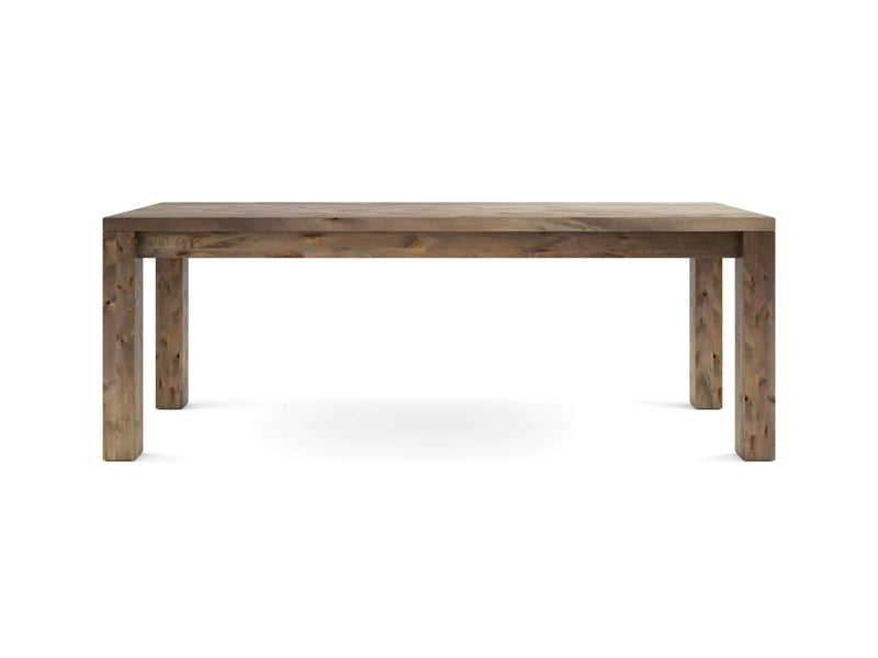 The Jonathan Desk - Barn Wood from James+James features a rustic wooden design with a rectangular top and four sturdy legs. Displaying a natural finish with visible grain patterns and knots, it exudes a vintage, handcrafted appearance. The desk is showcased against a plain white background.