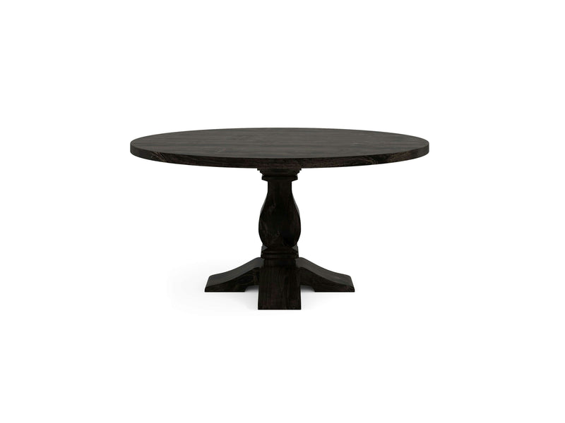 The Heirloom Round Dining Table - Charred Ember by James+James showcases a dark wood with a single ornate pedestal base supported by four feet. The tabletop has a smooth finish, and the base boasts elegant carved details, offering a classic and sturdy appearance.