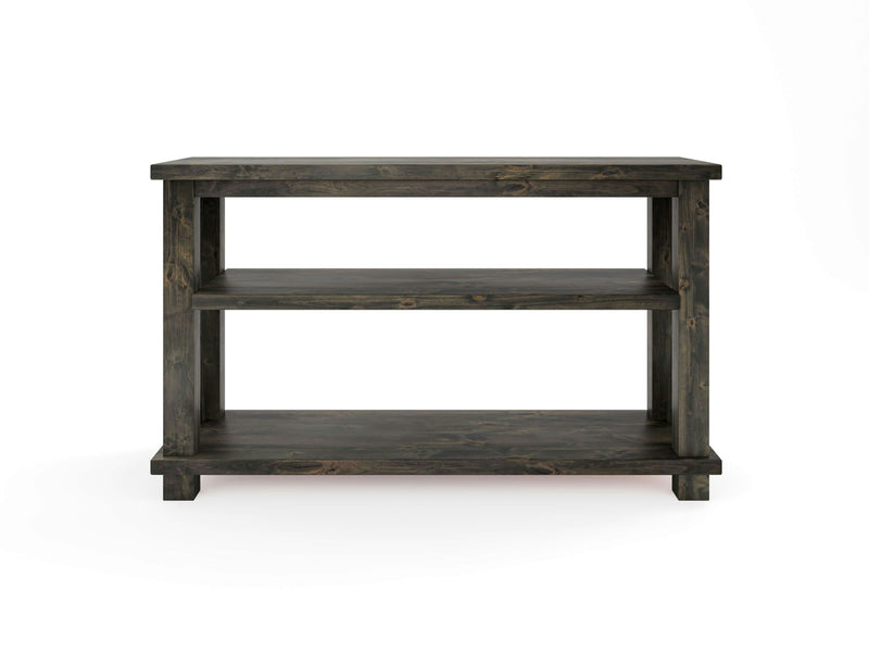 Introducing the Carter X Sofa Table by James+James: a compact, deep grey wooden table featuring a rectangular top and two lower shelves. The table stands on four square legs and showcases a simple, rustic design with no visible decorations or additional features. Set against a plain white background, it exudes understated elegance.