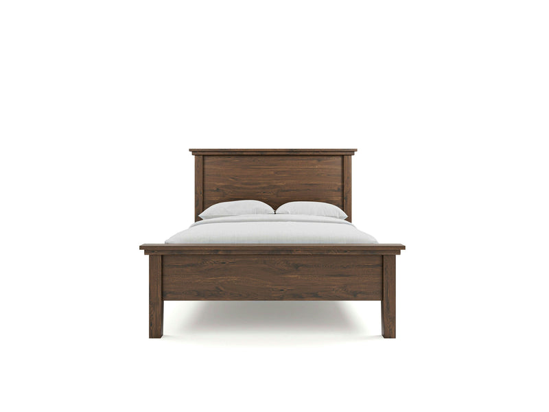 The Ivy Bed by James+James features a minimalist wooden frame made of dark polished wood. Shown from the front, it has a tall rectangular headboard and is neatly dressed with white bed sheets and two gray pillows. The background is plain white, highlighting the deep grey hue of the bed.