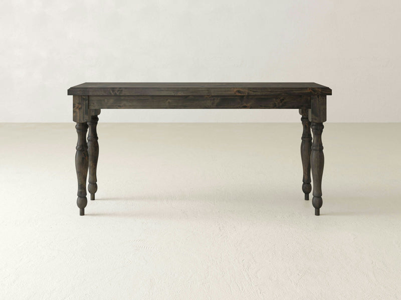 A dark wooden James+James Abigail Sofa Table with a rectangular top and four intricately carved legs is set against a plain, light-colored background. Its timeless charm is evident in the classic and robust design.