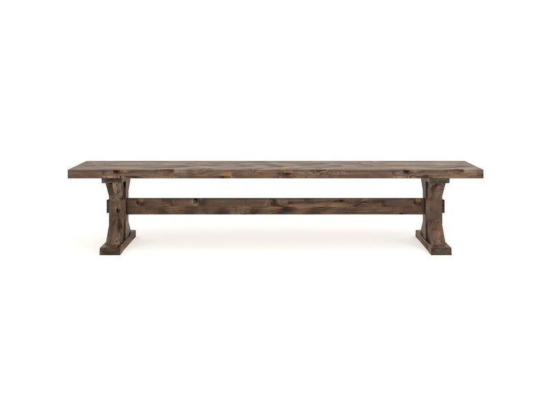 The Trestle Bench - Barn Wood from James+James features a rustic, sturdy design with a flat, rectangular seat and solid legs connected by horizontal supports. Its natural, weathered wood finish gives it a vintage and durable appearance.