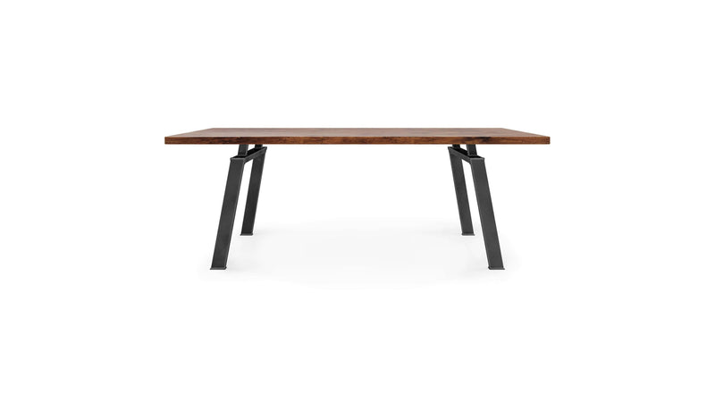 The Fulton Dining Table - Tuscany by James+James is a rectangular wooden table featuring a flat, smooth surface with a natural wood finish. It is supported by black metallic legs that angle slightly outward, offering a modern and minimalist aesthetic. The background is white.