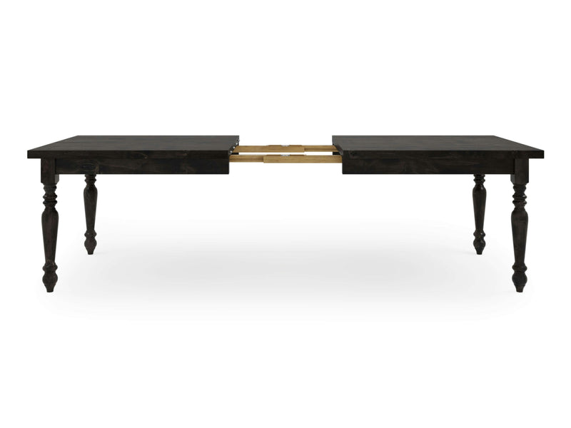 The French Country Expandable Dining Table - Charred Ember by James+James is shown. The table, characterized by its dark wooden finish, features four turned legs and a central split down the middle with visible metal extension mechanisms. It is partially extended, showcasing its adjustable feature with a gap in the center.