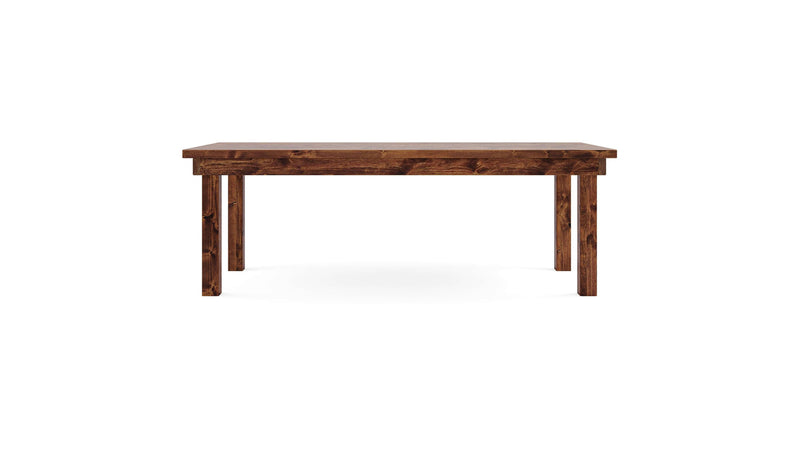 The Farmhouse Dining Table - Tuscany by James+James features a rectangular wooden design with a dark brown finish. This table is supported by four sturdy legs, each positioned at the corners, and boasts a smooth, flat tabletop. With its simple and functional design, it is ideal for dining or work purposes. The background is plain white.