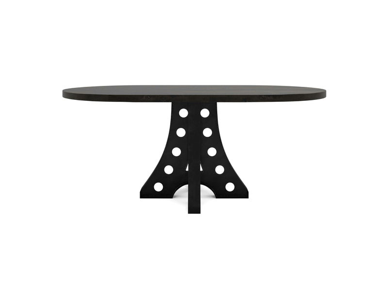 The Amelia Oval Dining Table in Charred Ember by James+James features a thick top and a leg design showcasing an arch shape with circular cutout patterns. The unique leg structure not only supports the tabletop but also adds a modern, stylish touch to this piece of furniture. The table is displayed against a plain white background.