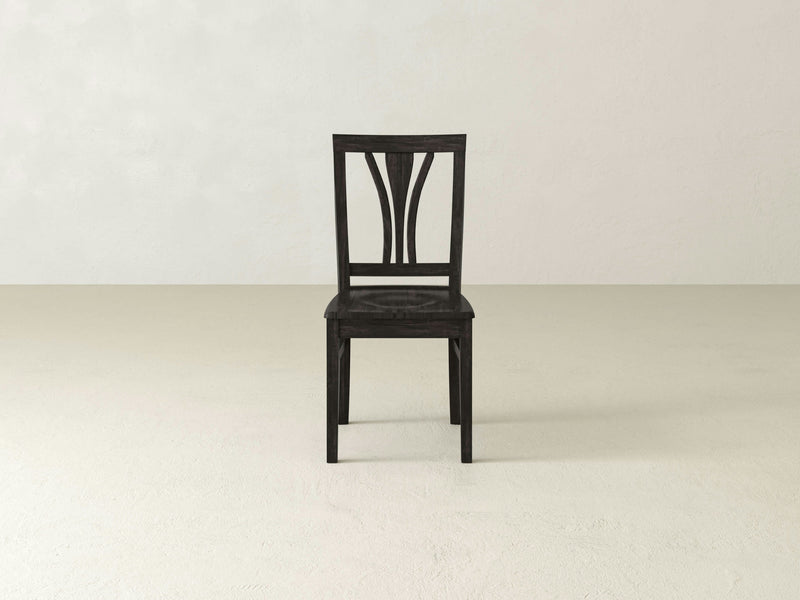 The Brooklyn Dining Chair - Charred Ember by James+James is showcased against a white background. This chair boasts a sophisticated and uncomplicated design, featuring a curved slat backrest and a smooth, flat seat. Its straight, robust legs underscore the classic and refined aesthetic of the piece.