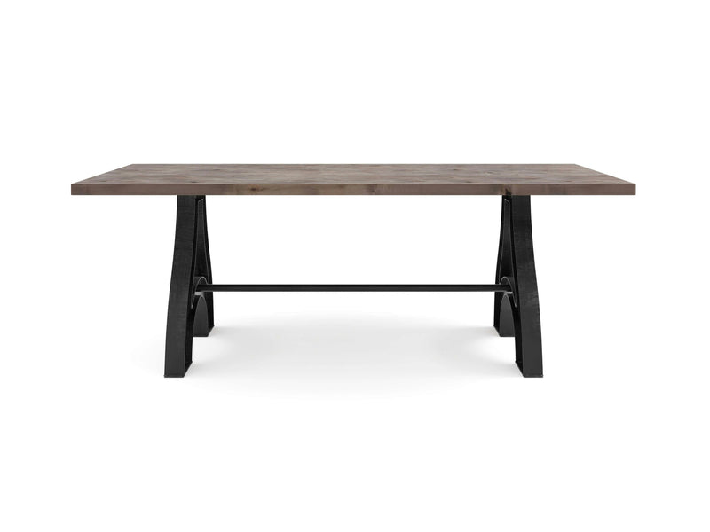 The Wishbone Dining Table - Barn Wood by James+James features a rectangular wooden tabletop with a rustic finish, supported by black metal trestle legs in a modern industrial design, complete with a crossbar for added support. The table is set against a white background.