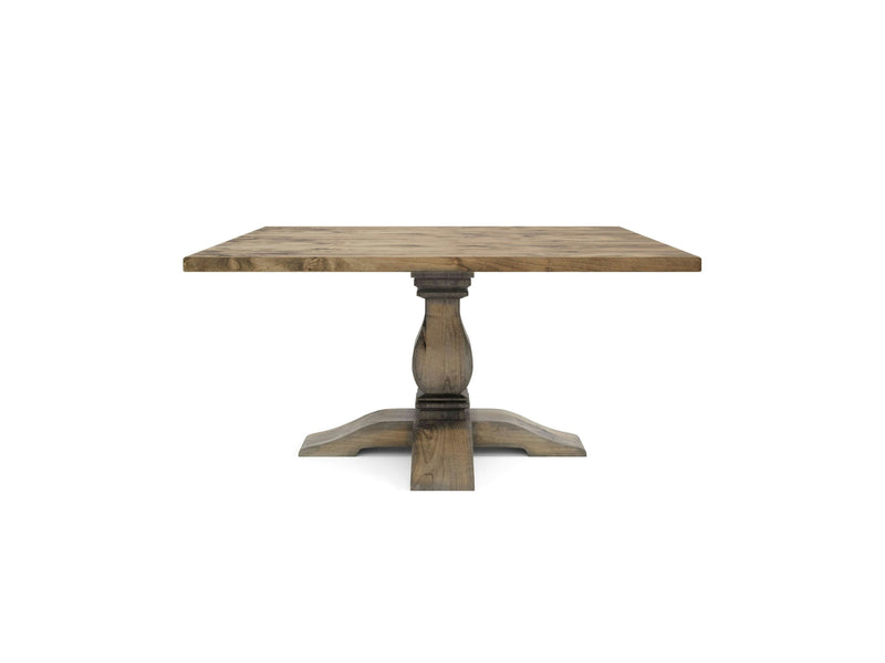 The Heirloom Square Dining Table - Harvest Wheat by James+James is a square wooden dining table with a rustic finish. It features a pedestal base with intricate carved details, supported by four sturdy legs extending from a central column. The natural grain pattern of the wood enhances its vintage appearance.