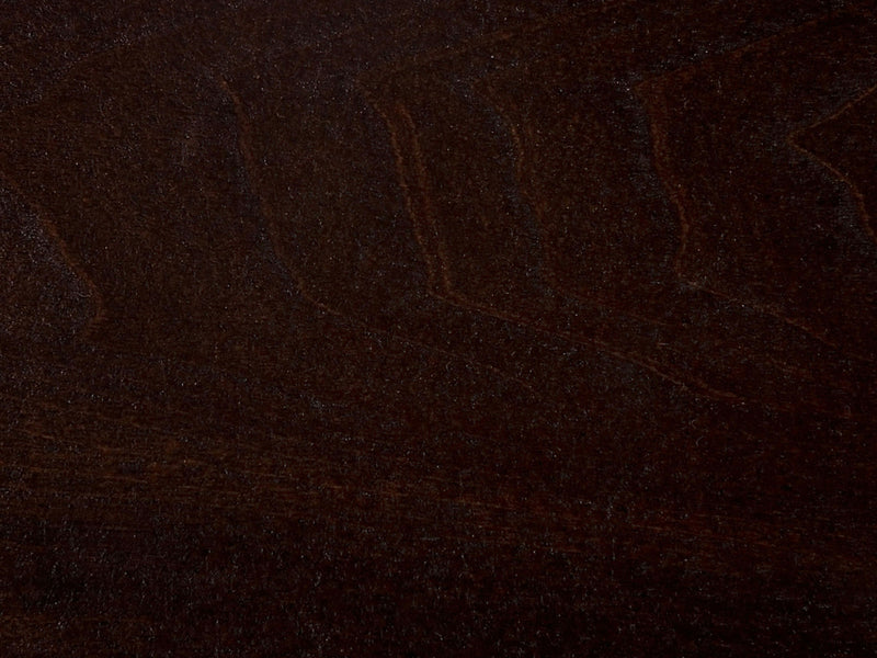 A close-up of the Tobacco on Black Walnut Sample from James+James showcases a dark brown wooden surface with subtle variations in texture and grain patterns. The wood boasts a rich, deep color complemented by a smooth, polished finish.