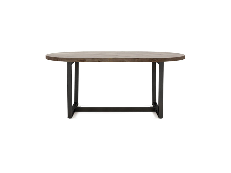 The Trapezoid Oval Dining Table - Barn Wood by James+James features a wooden oval surface in a smooth, light brown finish. It is supported by a sturdy black metal base that forms an H-shape, ensuring stability and balance. The table's modern and minimalist design makes it suitable for various room settings.