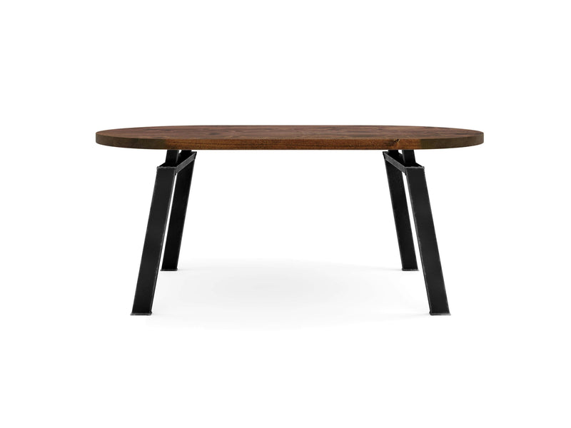 This is the Fulton Oval Dining Table - Tuscany by James+James, showcasing a smooth, natural wood grain on its round wooden tabletop. Seen from the front, it features a minimalist design with black metal legs that taper slightly outward, offering a modern and sturdy appearance.