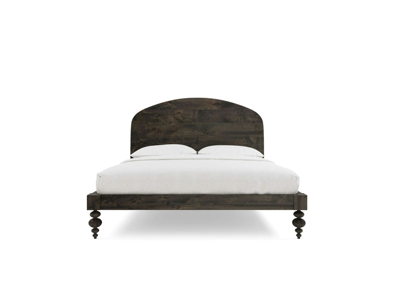 The Eden Bed - Deep Grey by James+James is featured, showcasing a dark wooden frame with an arched headboard and turned legs. The bed is perfectly made with white bedding, including pillows and a duvet. The design is simple yet exudes a rustic and classic charm. The background is white.