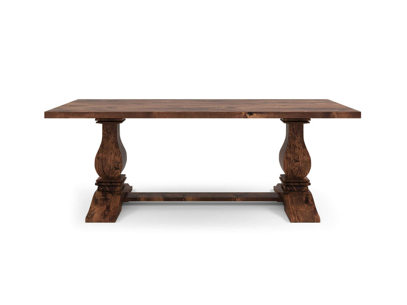 The Heirloom Dining Table - Tuscany by James+James boasts a rustic wooden design with a rectangular top and two ornate pillar-style legs connected at the base by a horizontal support beam. It features a dark rich brown color with visible wood grain patterns.