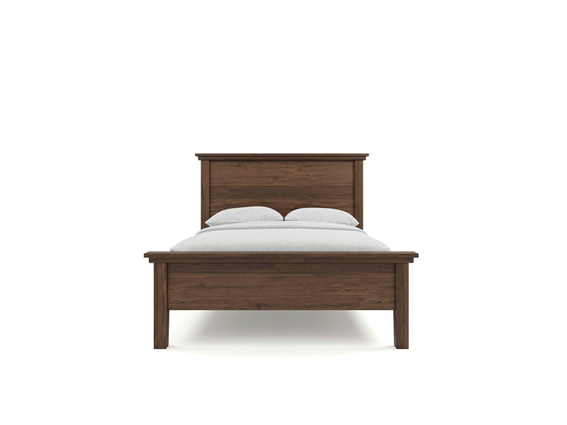 The Ivy Bed - Tobacco, crafted by James+James, showcases a dark brown wooden frame with a high headboard and a lower footboard. The bed is neatly made with a white sheet and two white pillows. The design is simple and elegant, set against a plain white background.