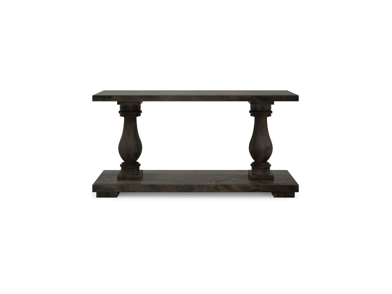 The Vivien Sofa Table by James+James features a deep grey, dark wooden rectangular top, supported by two ornate turned legs and a solid base. Its simple yet elegant design with a rustic finish makes it suitable for various interior decor styles.