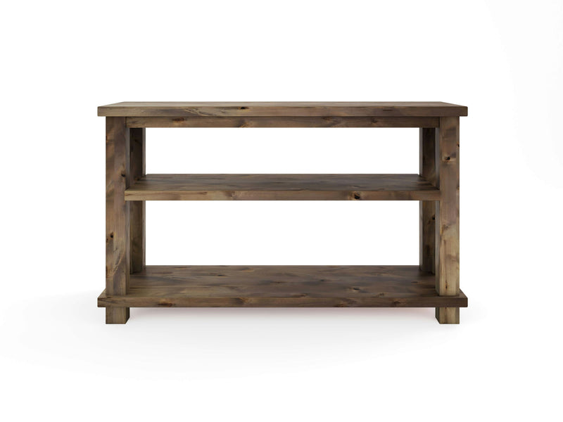 The Carter X Sofa Table - Barn Wood by James+James is a wooden side table boasting a rustic finish. It features a rectangular top surface, a middle shelf, and a bottom shelf, providing ample storage or display space. The table has a sturdy, simple design with clean lines and an elegant natural wood grain pattern.